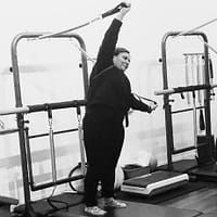 woman doing a sidebend in a tower pilates class