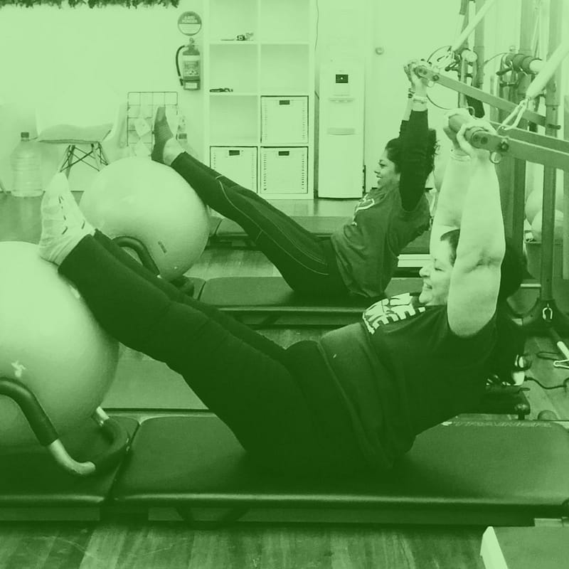 Class Times 1 smiling women doing tower pilates