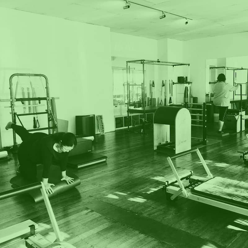 Our Classes 8 women doing balance exercises in a 360 studio pilates class