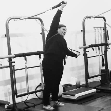 Woman doing a sidebend in a Tower Pilates Class